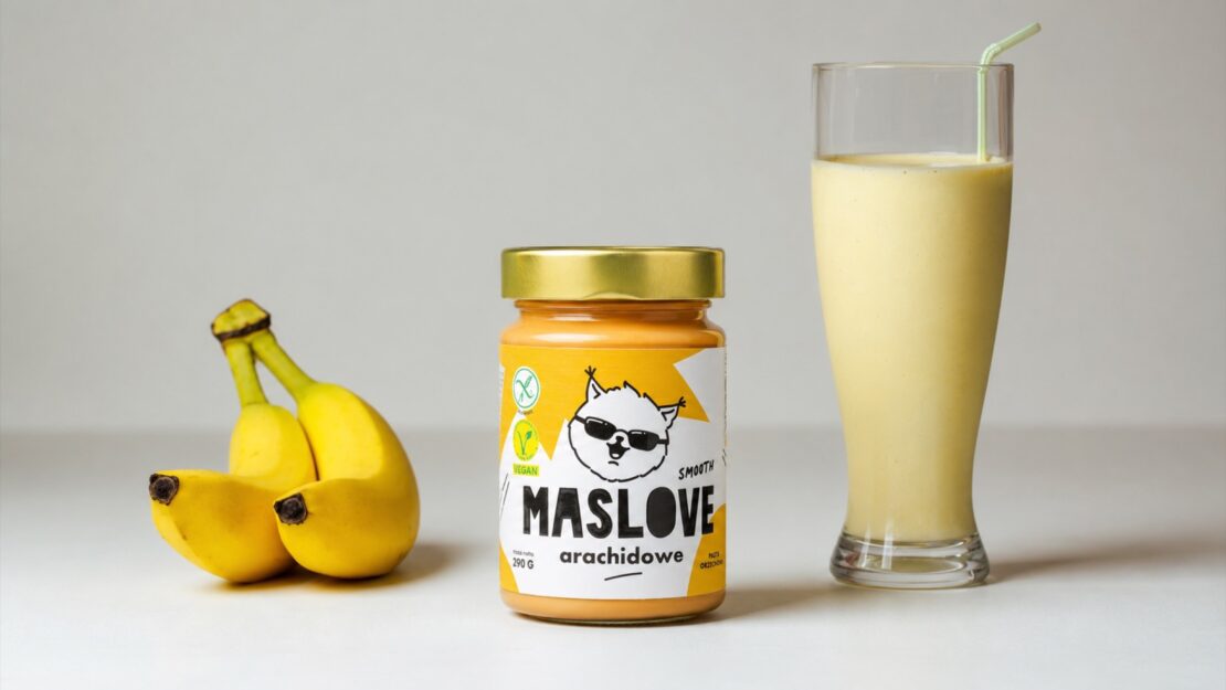 Smoothie z maslem orzechowym i bananem w szklance, obok sloik Maslove